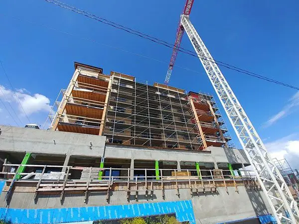 A crane is in front of the building under construction.