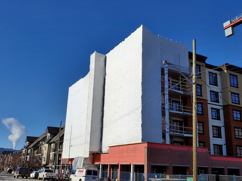 A building with two large windows on the side of it.