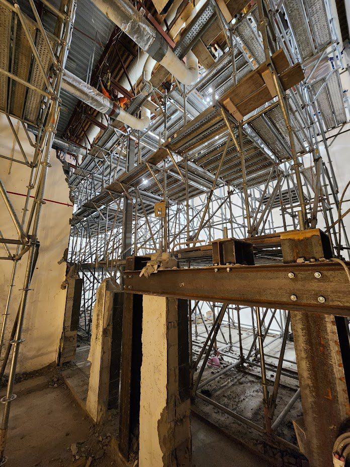 A building with scaffolding and wooden beams on it.