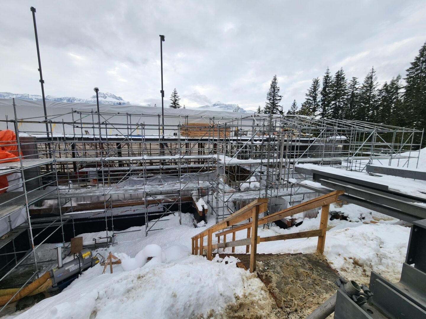 A view of some stairs and scaffolding in the snow.