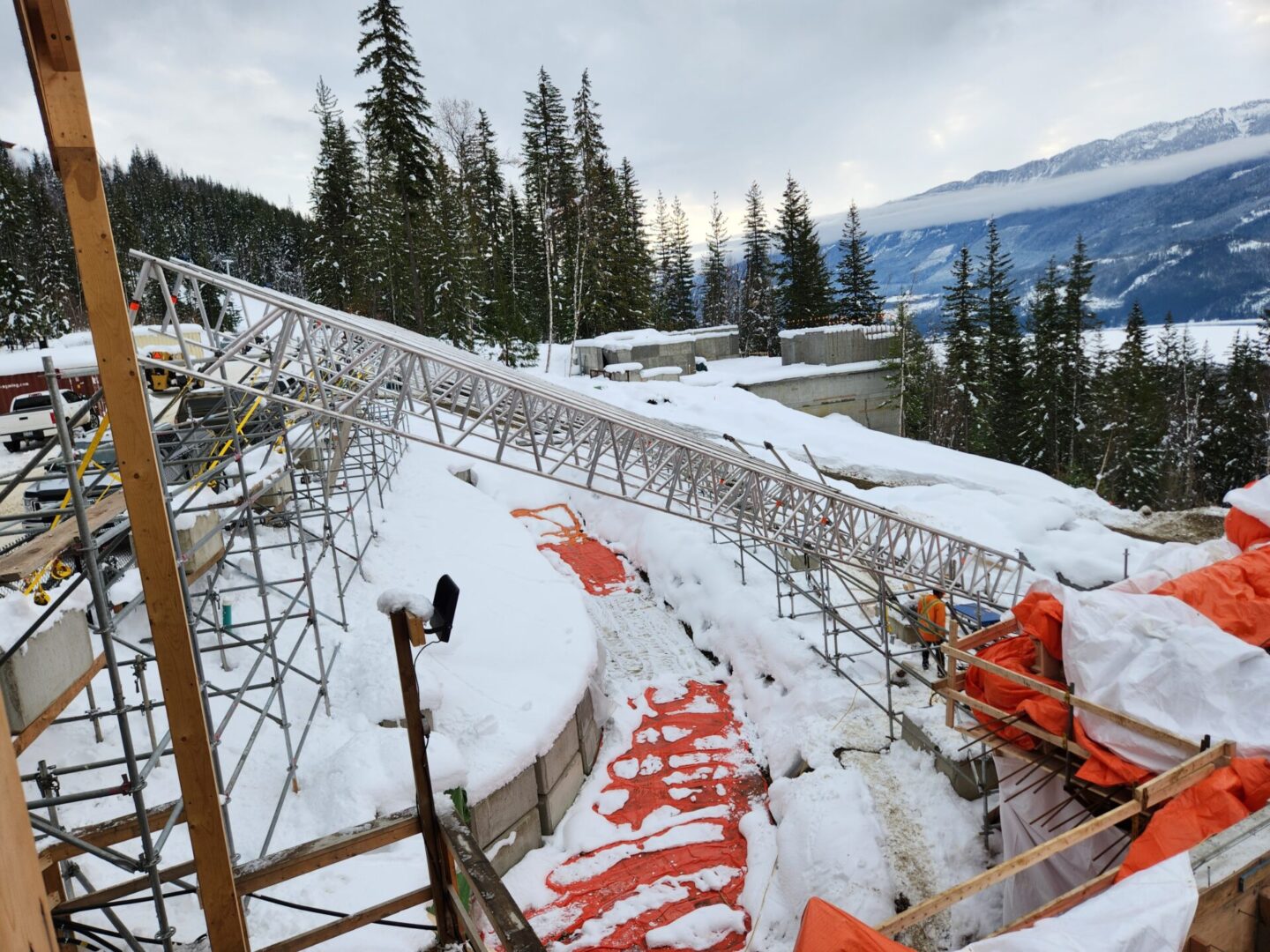 A ski slope with snow and trees in the background.