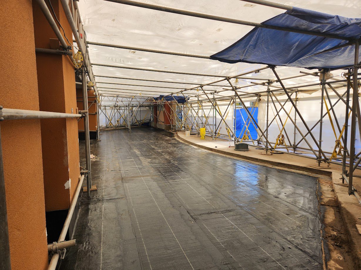 A room with scaffolding and tarps on the ceiling.